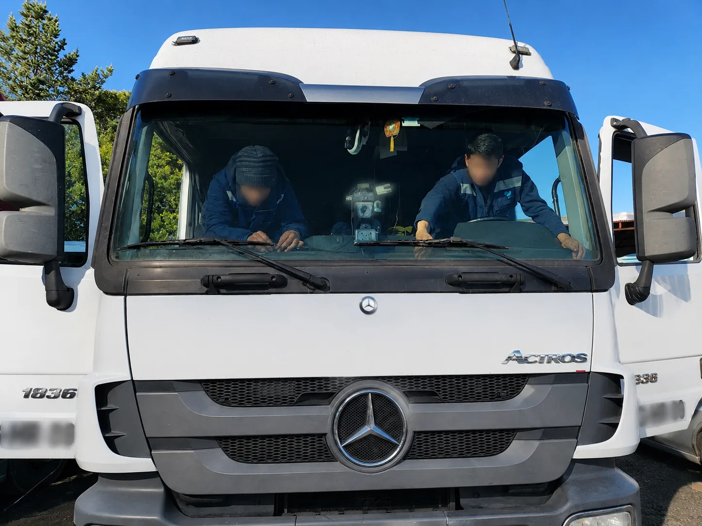 Dos técnicos instalando equipos dentro de la cabina de un camión.